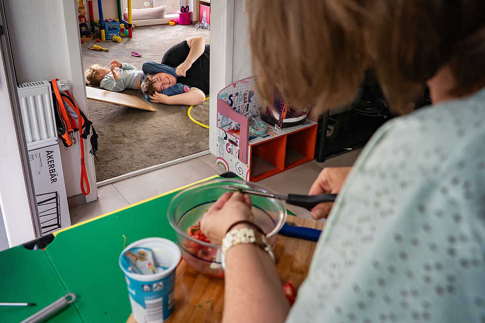 Frau schält Gemüse und Kinder spielen auf Teppichboden