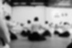 Praticantes de quimono e hakama alinhados em meditação e aquecimento durante as aulas de aikido no En Dojo. O registro captura a disciplina e o respeito presentes na rotina desta tradicional academia de artes marciais em São Paulo.
