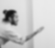 Foto em preto e branco de perfil de um instrutor de quimono estendendo a mão aberta em sinal de convite no tatame. Imagem perfeita para botões de agendar aula de aikido ou para marcar uma aula experimental aikido no En Dojo.