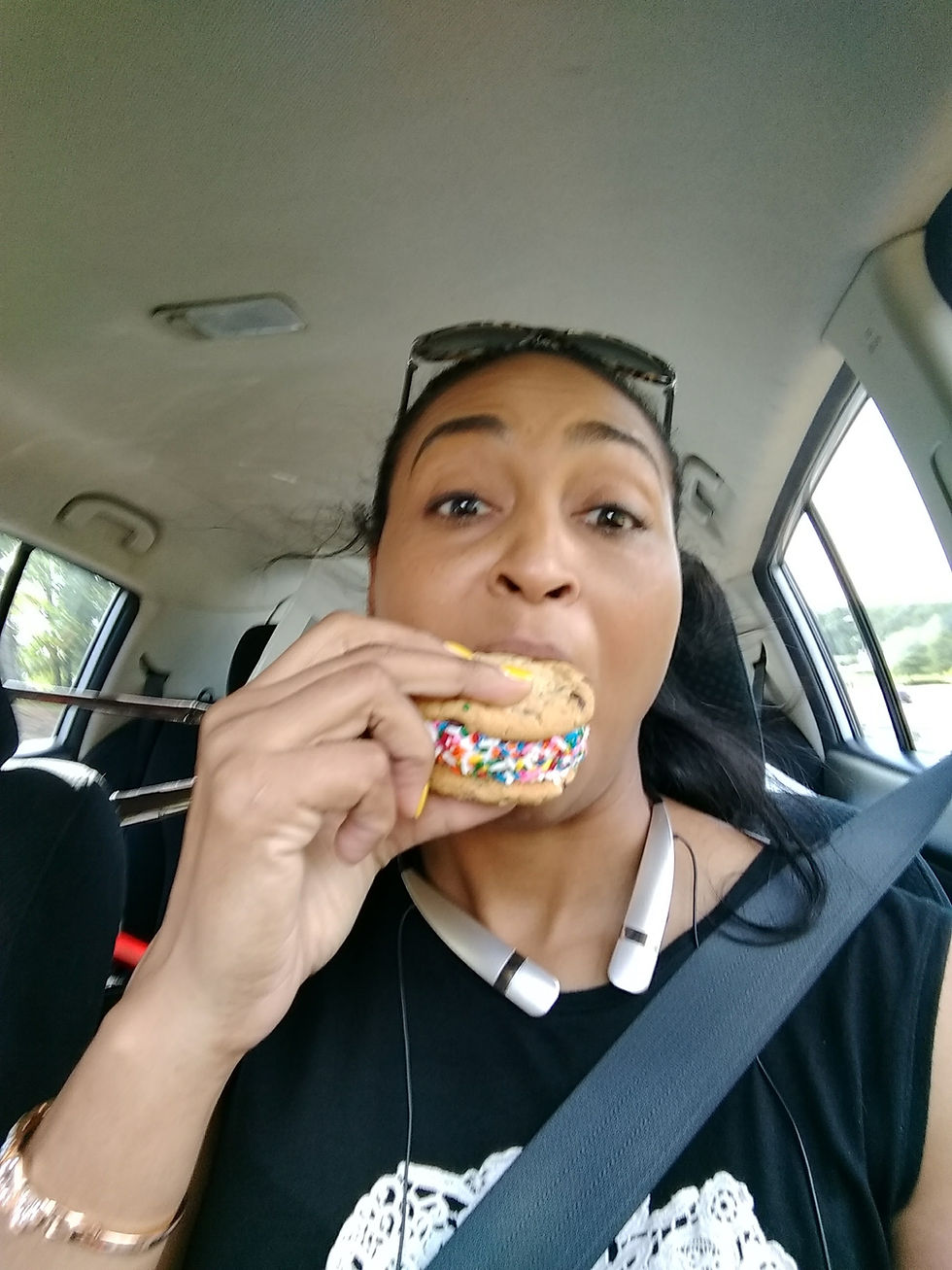 Chandra taking a big bite of a cookie filled with icing.