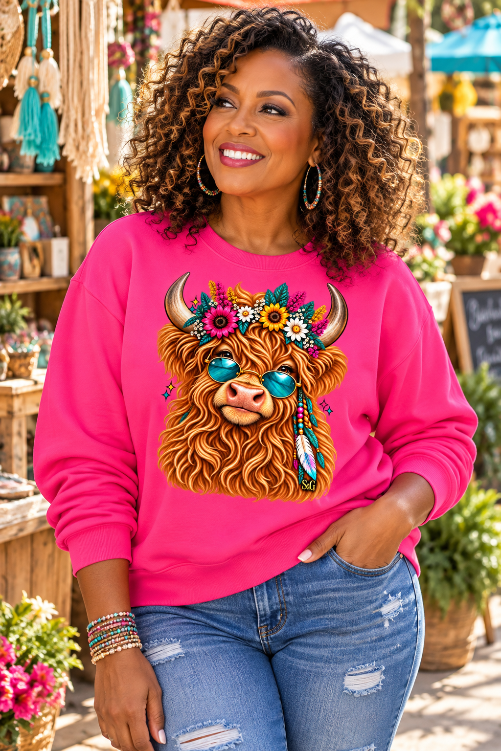 Woman wearing a Heliconia pink S&G Boho Highland Cow crewneck sweatshirt featuring a colorful floral Highland cow graphic.