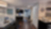 View of A-84 vacation home’s front entrance from the living room and kitchen area, with dining table and cupboard for glasses visible
