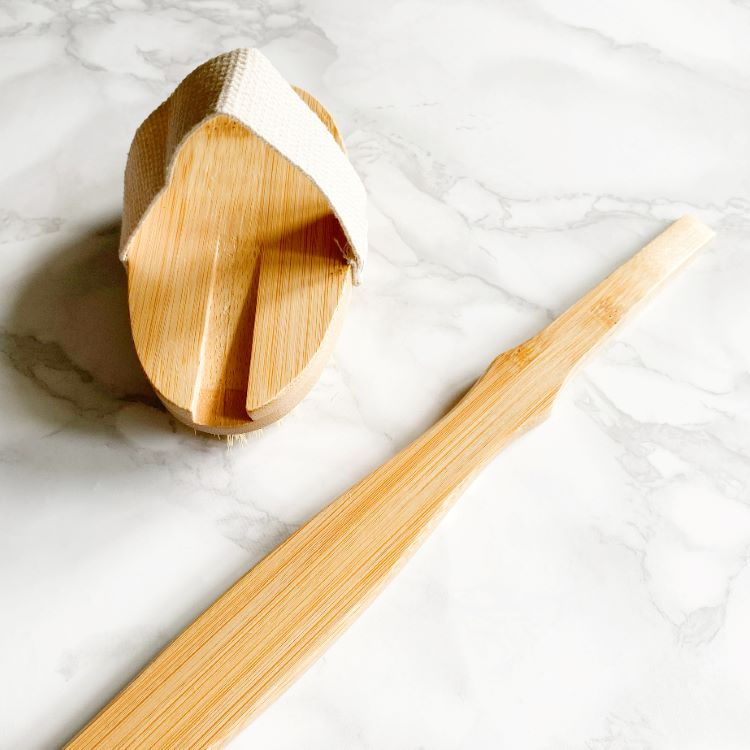 Thumbnail: Long wooden bath brush separated into the handle and the removable head