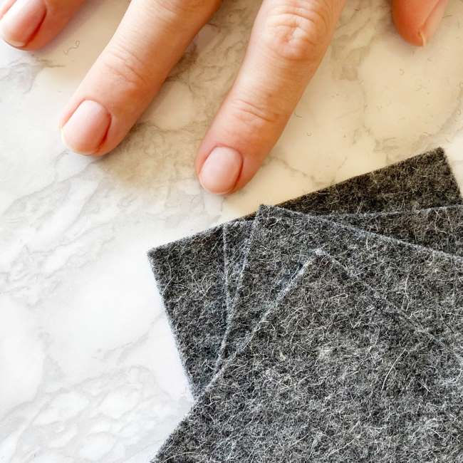Thumbnail: Hand with nail varnish removed next to three reusable nail varnish remover pads