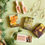 Thumbnail: Detailed view of some of the eco-conscious cracker fillers, arranged on a green background and with Christmas foliage around