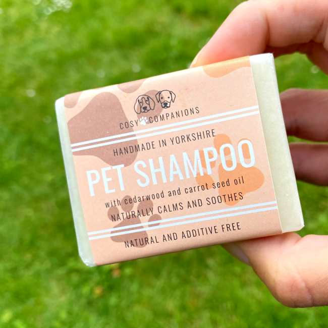 Thumbnail: Hand holding a bar of natural dog shampoo enriched with cedarwood and carrot oil