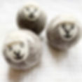 Three tumble dryer balls made of felted wool with cute sheep faces