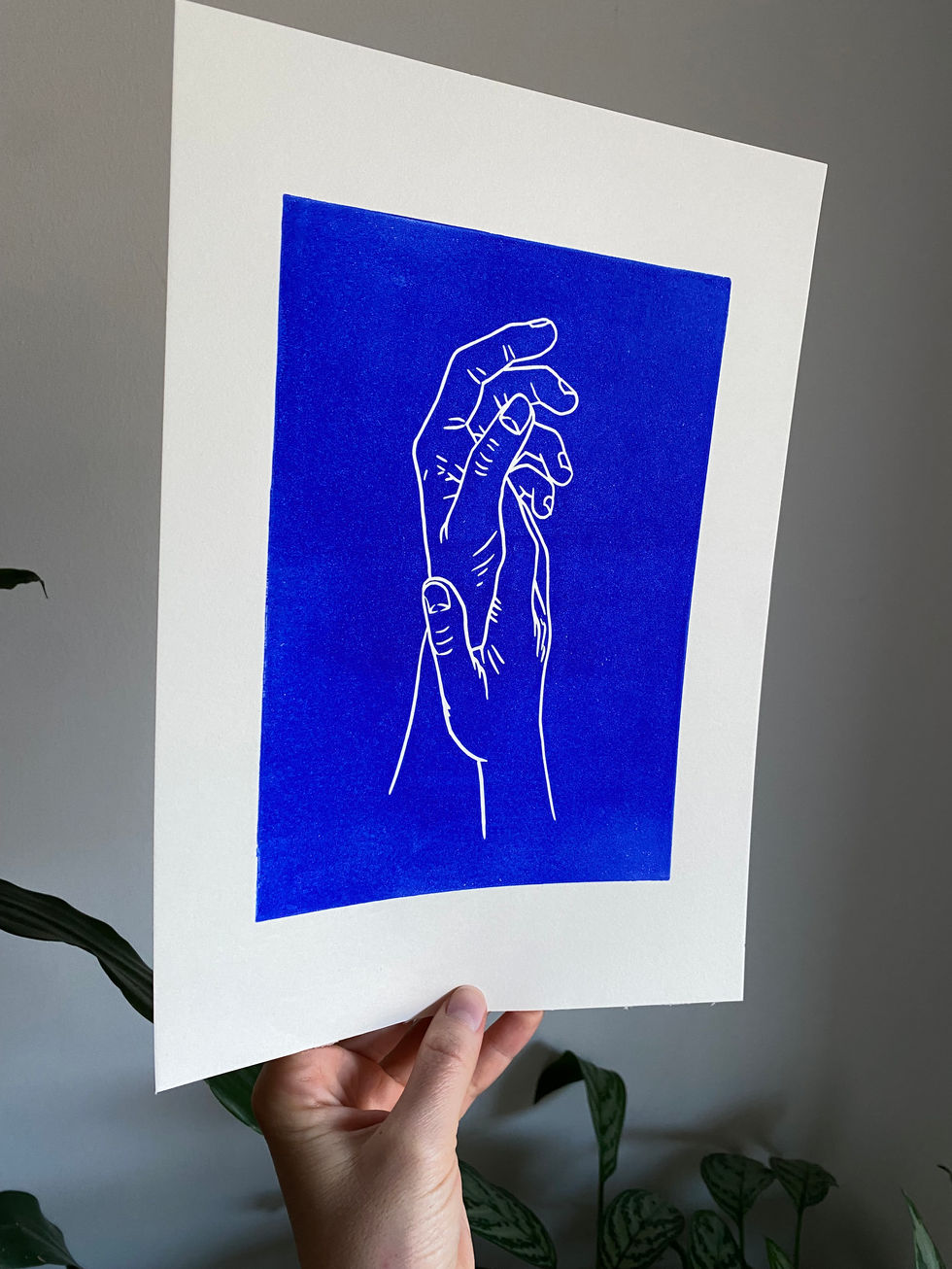blue linocut print of two hands