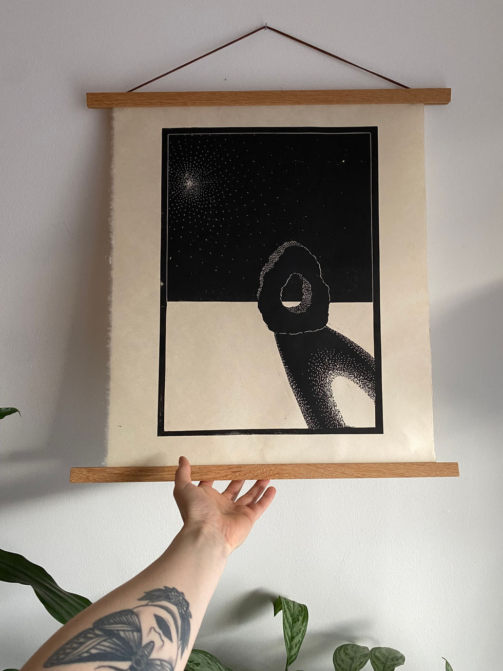 Abstract linocut print of stone artwork hanging on a wall