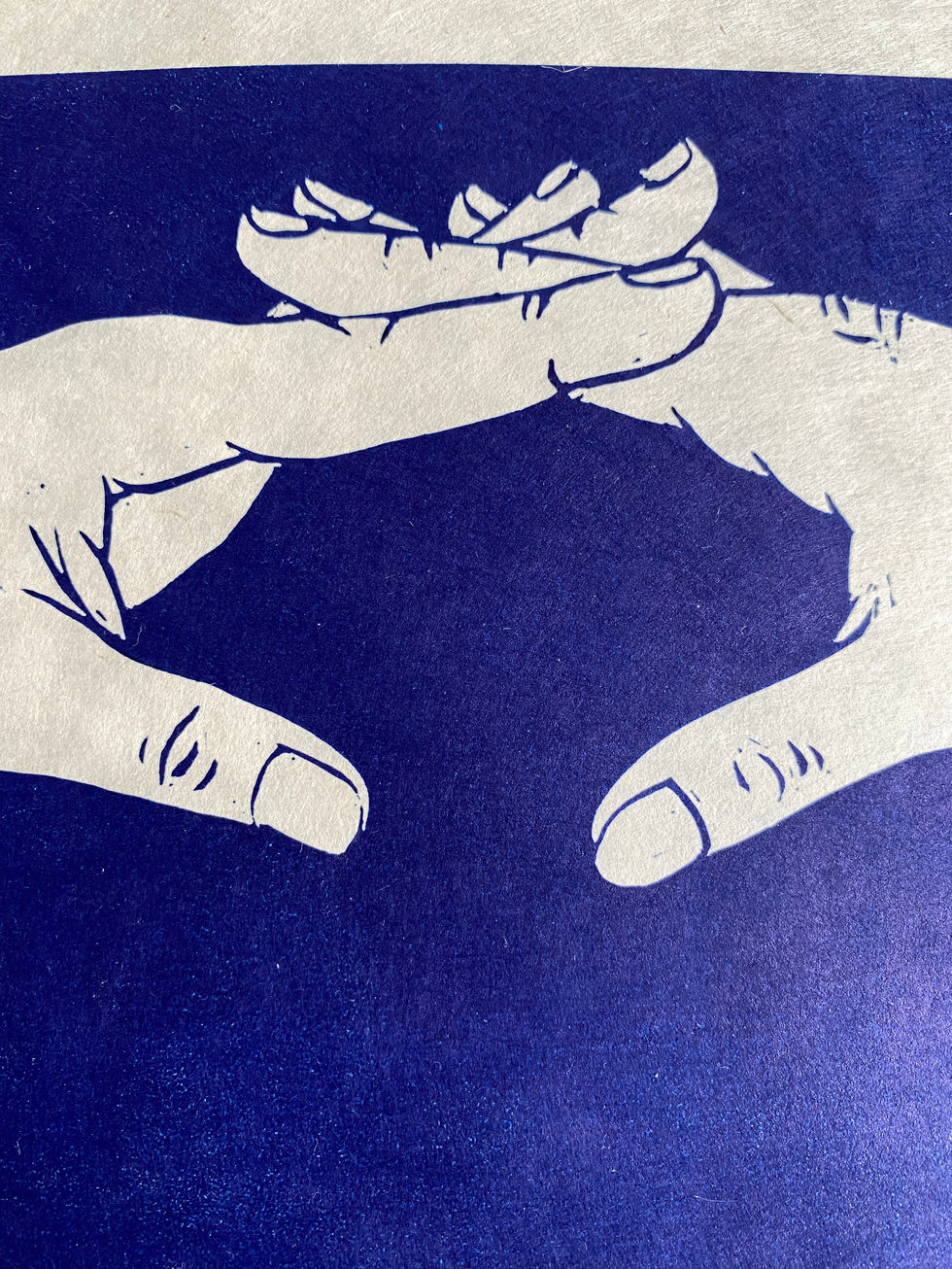 dark blue linocut print of two hands formed into an arch