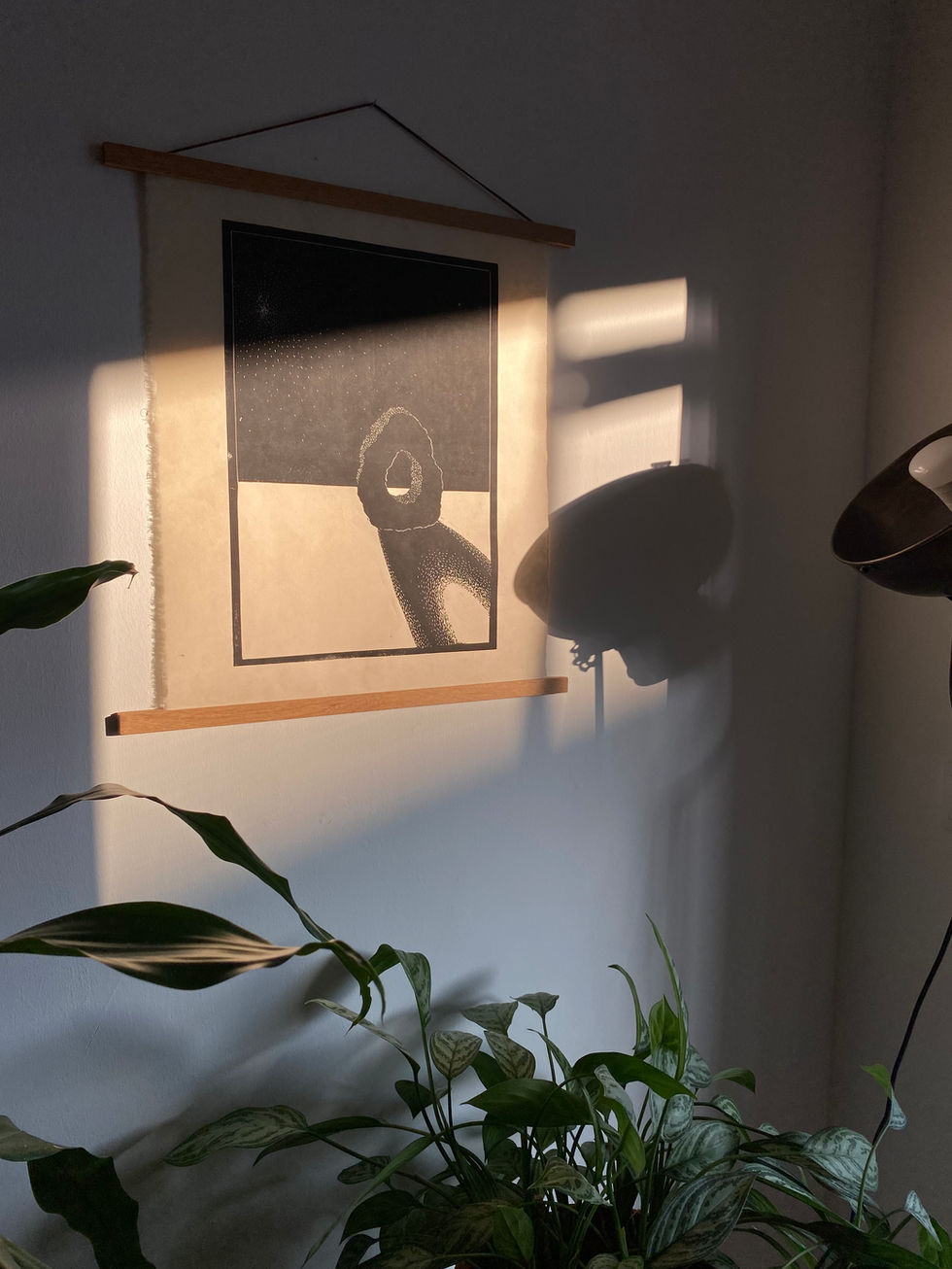 Abstract linocut print of stone artwork hanging on a wall