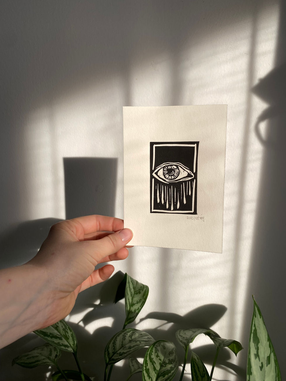 black linocut print of a crying eye