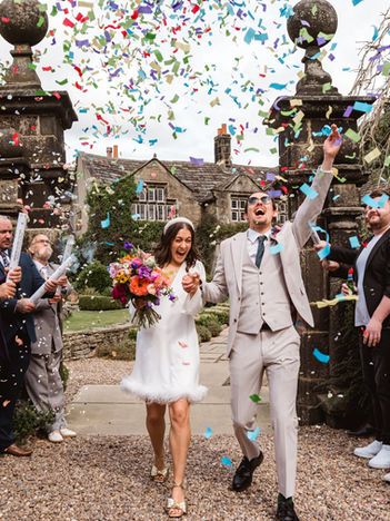 Couple in colourful confetti outside Holdsworth House