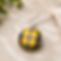 Round pendant necklace featuring Cornish tartan fabric in yellow, black and red tones, dis