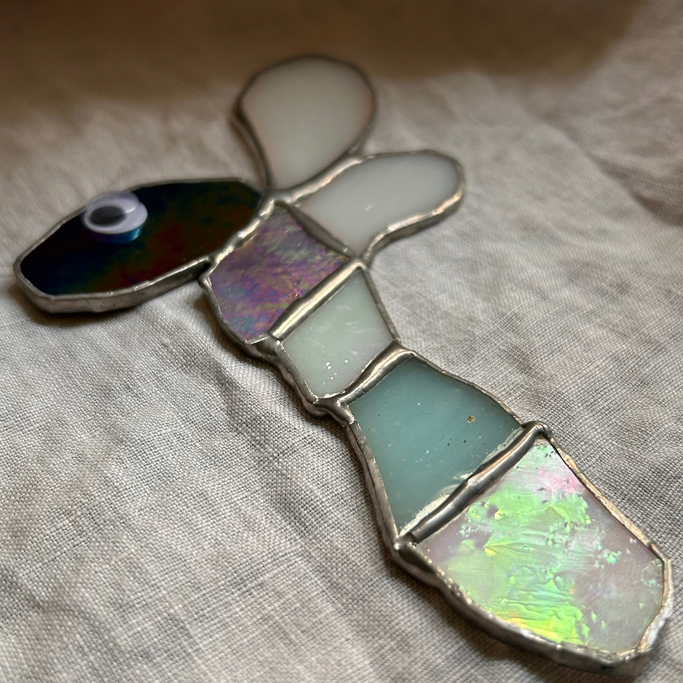 Handcrafted stained glass bug hanging showing wings and body from a side angle