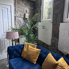 A photo of the downstairs room available to hire in Penzance. The photo features a calm, nature-inspired theme with green foliage accents. Text reads: ‘Downstairs Room to Hire – Penzance. Looking for a calm, private space in the heart of Penzance? Our comfortable, discreet downstairs room is now available to hire.’ It lists ideal uses such as counsellors, therapists, one-to-one sessions, small groups, and workshops. It highlights included amenities: comfortable seating, high-speed Wi-Fi, a private quiet atmosphere, kitchenette, and toilet facilities, describing the space as welcoming and professional.