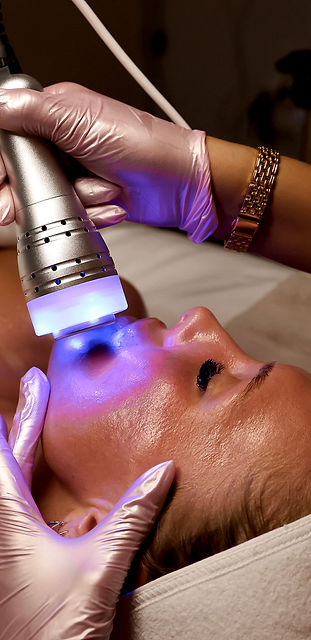 Axie, owner of Faced Esthetics in Wichita, KS, applying a face mask to promote the studio's facial services.