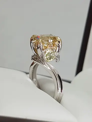 This is an organic design based around the story of the Goddess Idun, from Norse myth. It has a stunningly cut round stone at the centre with smaller green diamonds to signify the apple's from the story of Idun herself. 
