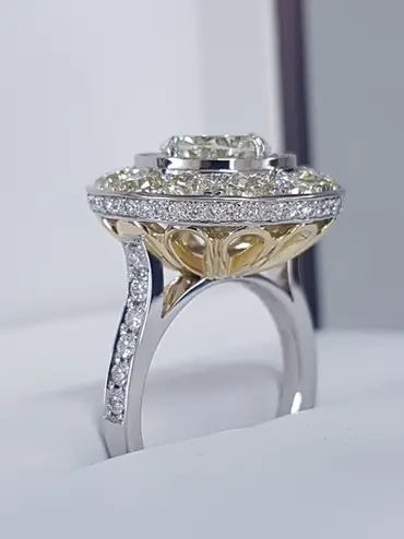 This is a large button backed halo ring with two stepped diamond set sections in the main halo. The main stone is a historical find of a 2.37cts mixed transitional cut natural diamond.