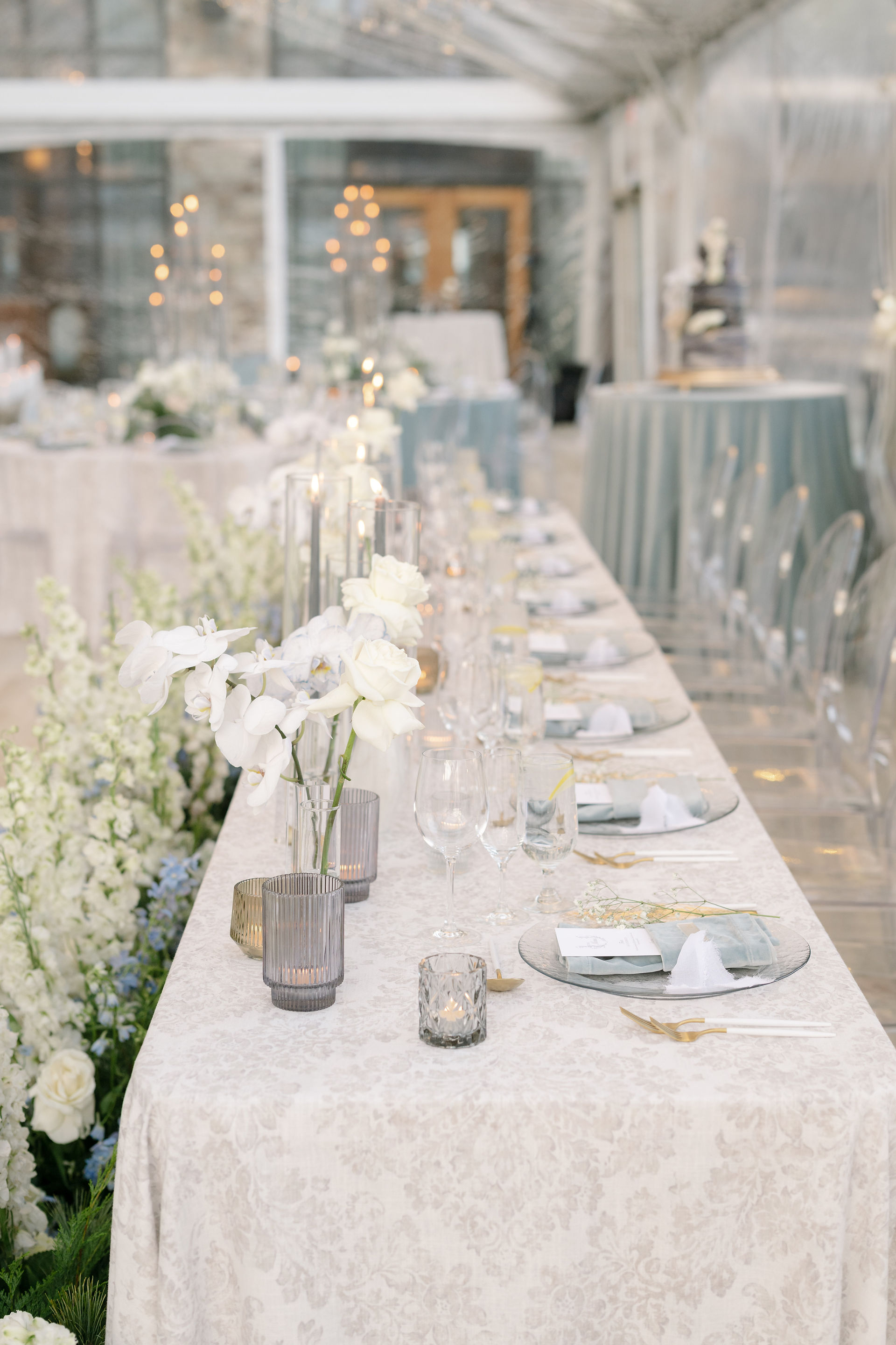 Elegant candlelit reception tablescape with white florals and layered linens at luxury Park City wedding reception