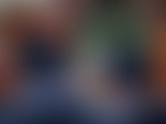 HaRav Chaim Peretz Berman, with a long white beard, wearing a dark suit and kippah, stands at a wooden podium with a seven-branched menorah and an open book, delivering a lecture in a richly decorated synagogue. The background features a green curtain with floral embroidery and Hebrew text, with ornate wooden architecture and a green chair visible.