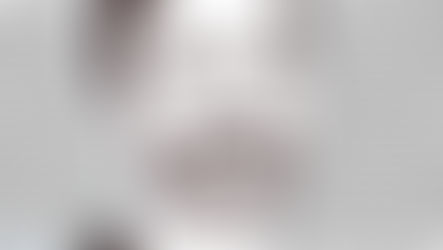 A black-and-white illustration of Zohran Mamdani, smiling confidently with eyes partially closed, set against a repeating pattern of cartoon poop emojis filling the background. The portrait is in a sketch-like style with detailed hair, beard, and suit, while the poop icons are grayscale and arranged in neat rows. Artist signature "Yhers" appears in blue at the bottom right, with "sheinast.com" in small text at the bottom left.