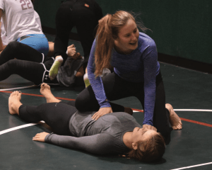 Lilley Salmon '18 practices a Jiu Jitsu take down she had just learned on Siclair Seeligson '18. Credit: Will Briskin