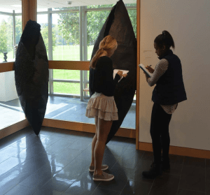 Mimi Pastor ‘19 and Nicole Da Cista ‘19 studies “Hesitant Moment Between Onset and Completon” in the Von Ausperg Gallery. Credit: Olivia Jones