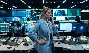 Rebecca Ferguson talking on the phone in the White House's situation room.