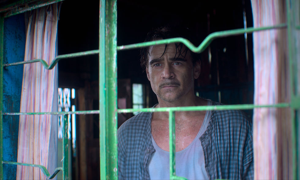 Colin Farrell looking out the window that has green bars on it.