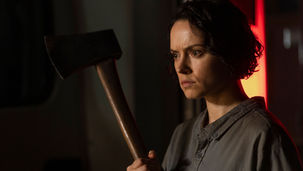 Daisy Ridley holding an axe.
