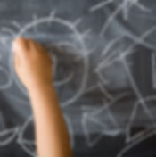 Child drawing on chalkboard