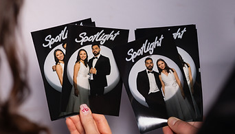 Hands holding photo print outs with spotlight lighting