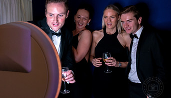 A group of people standing in front of a photo booth