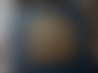 Blue leather book with ornate gold emblem: "Ultimate CBSE Class 12 English Study Guide." Pens and books in a library setting.