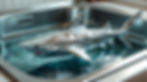 A shiny origami shark made of foil floating in a sink of water.