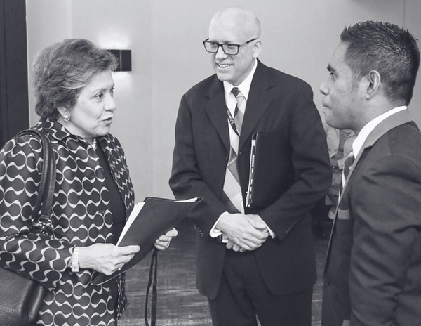 Three professionals in discussion at conference