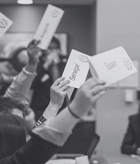 Hands hold up country name cards: Egypt, Angola, Senegal, Spain