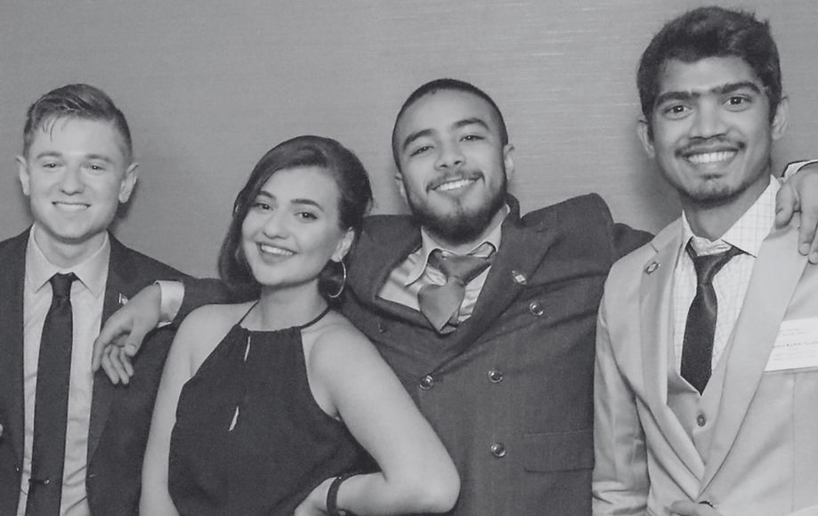 Four smiling young adults in formal wear