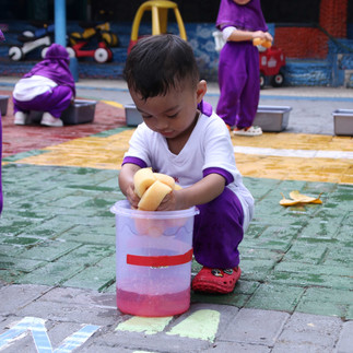 Murid memindahkan air dari satu tempat ke tempat yang lain menggunakan spons