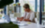 A senior woman sits at home with a laptop, focused on her work