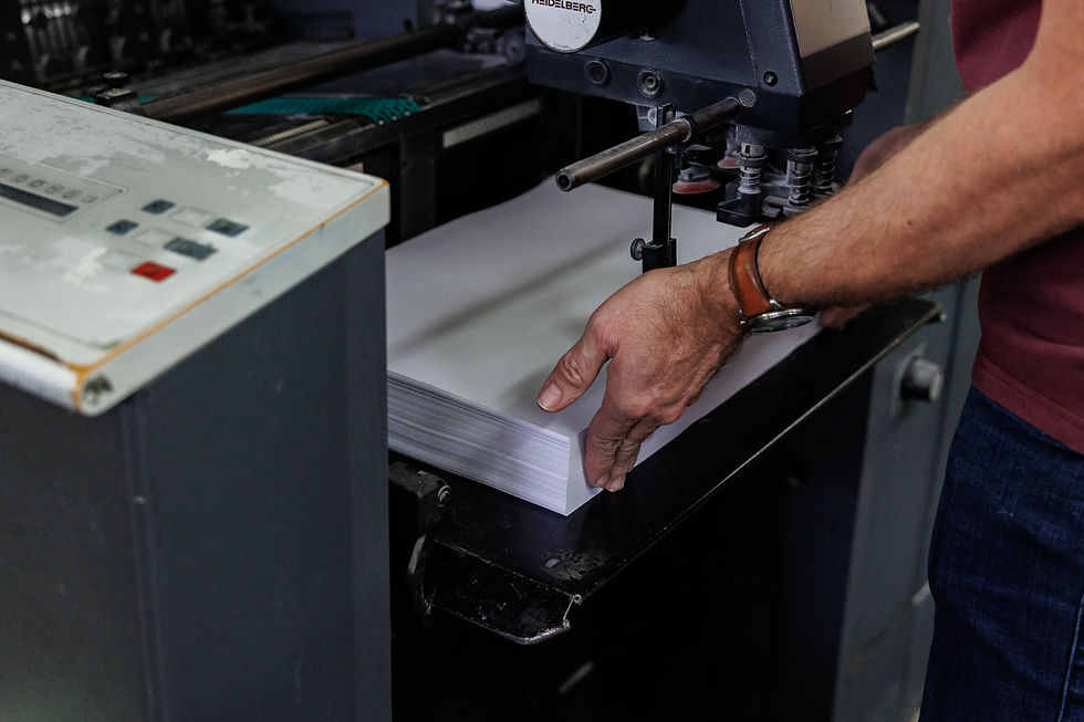 Print technician operating commercial printing press for business printing solutions.