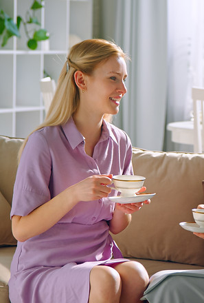 young-daughter-and-elderly-mother-drinking-tea-at--Q96CWV7.jpg