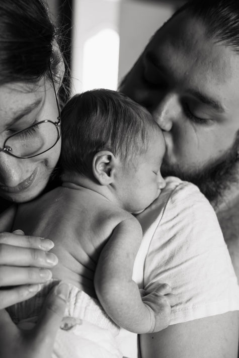 Photo de bébé dans les bras de ses parents en noir et blanc à Schweighouse par C. Mary Photographie