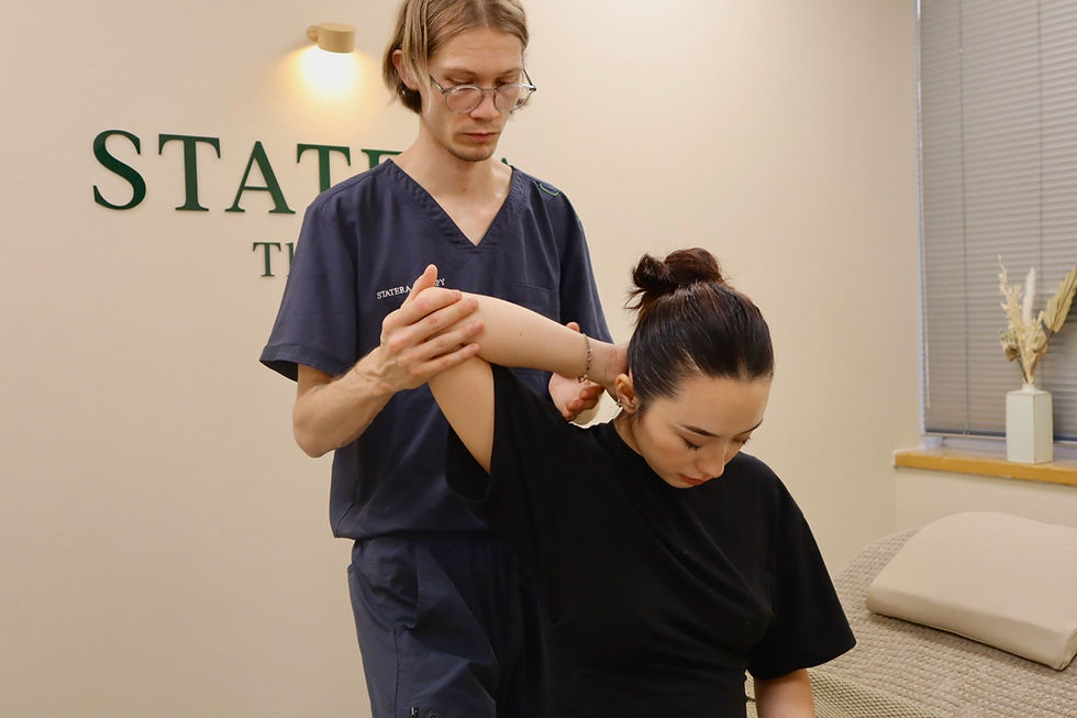 Harrison assessing shoulder movement during a Sports Therapy appointment in St Albans.