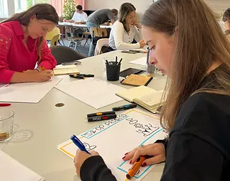 Deelnemers tekenen een praatplaat tijdens de workshop zakelijk tekenen