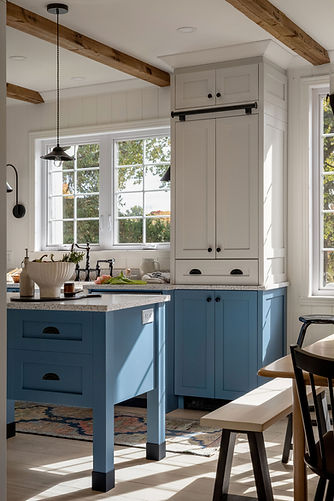 Cuisine lumineuse avec armoires bleues, rangements blancs et poutres en bois