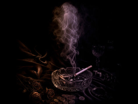 a lit cigarette in an ashtray, the smoke curls up and looks like a naked woman