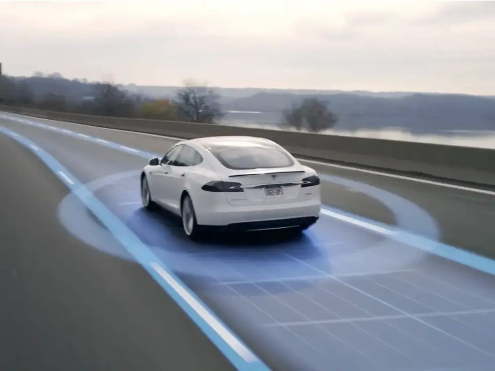 The image shows a white Tesla car on a highway with visualized blue autonomous driving lines, indicating advanced self-driving technology or an autopilot in action.