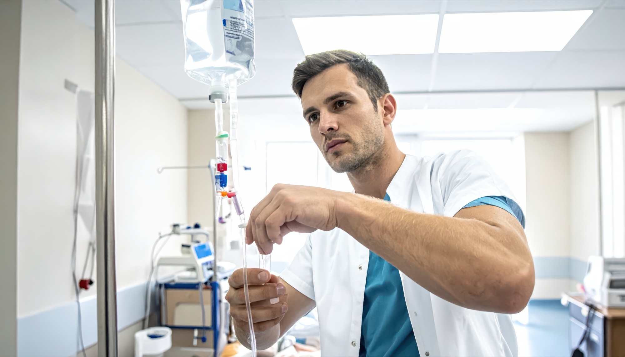 A clinician in a clinical setting carefully setting up an IV infusion line